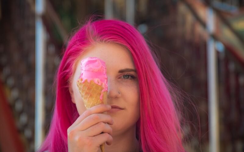 Vibrant neon pink hair against bathroom mirror light