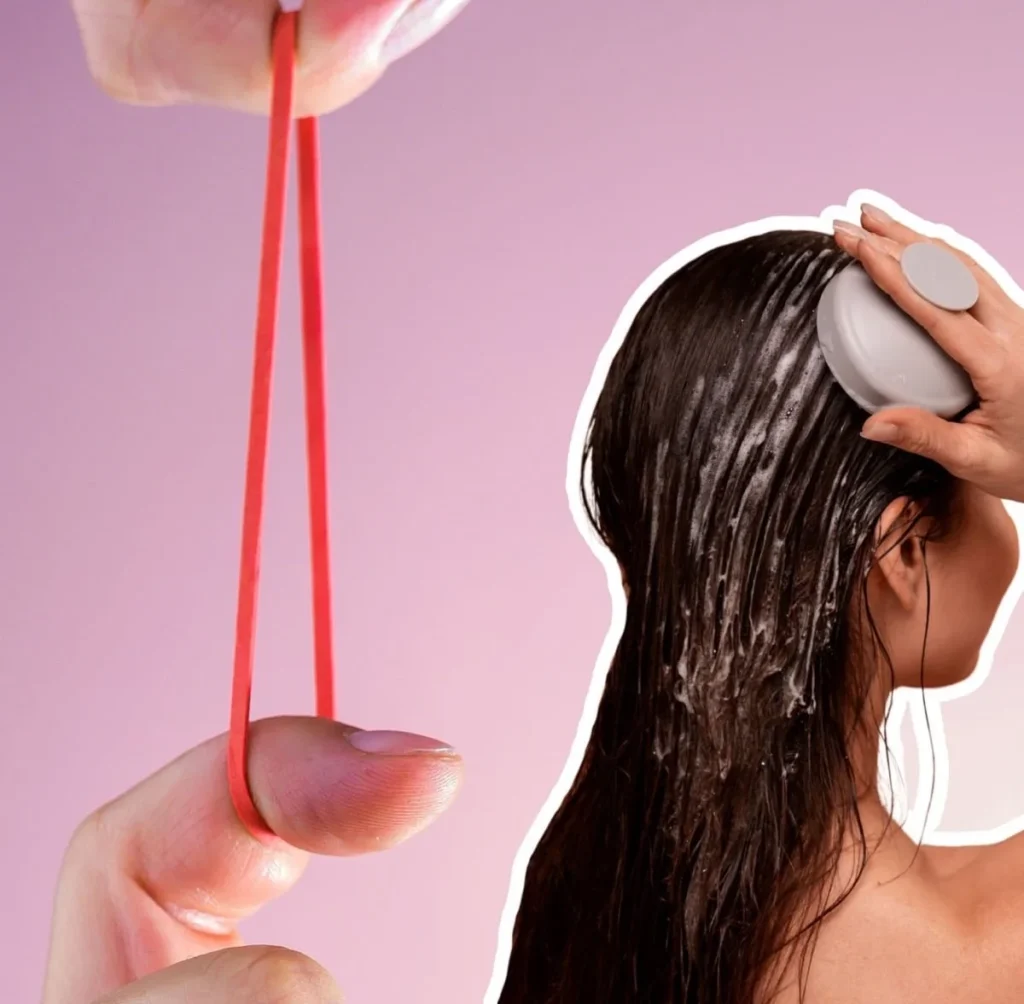 Wet hair being massaged with scalp cleanser and rubber band